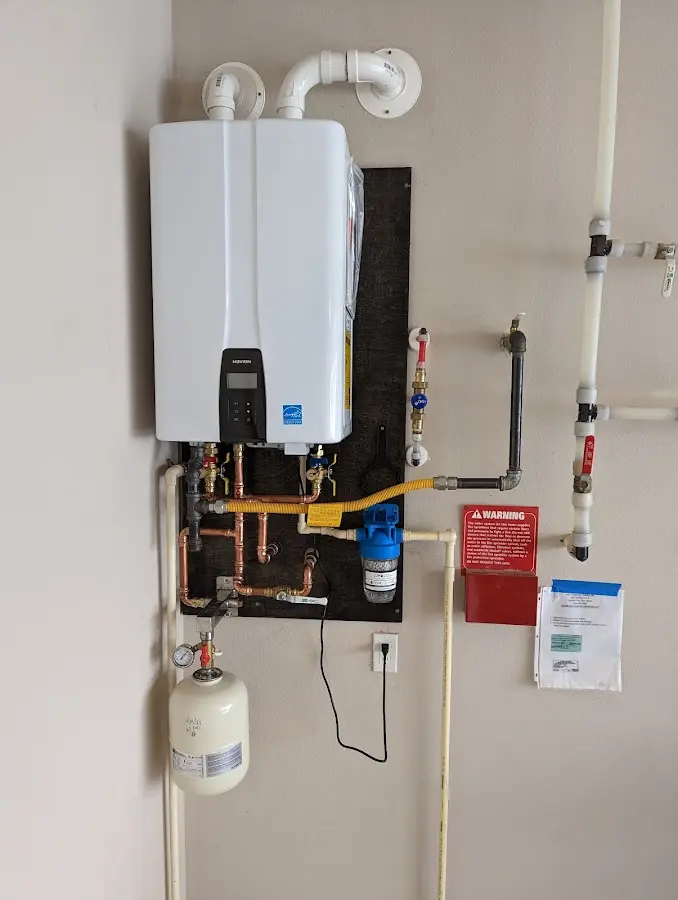 Professional plumber installing copper piping in a Troy home